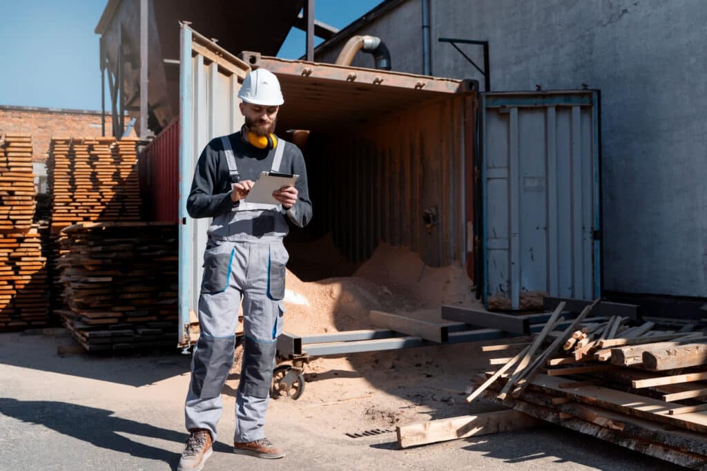 Obrero con un contenedor de obra detrás